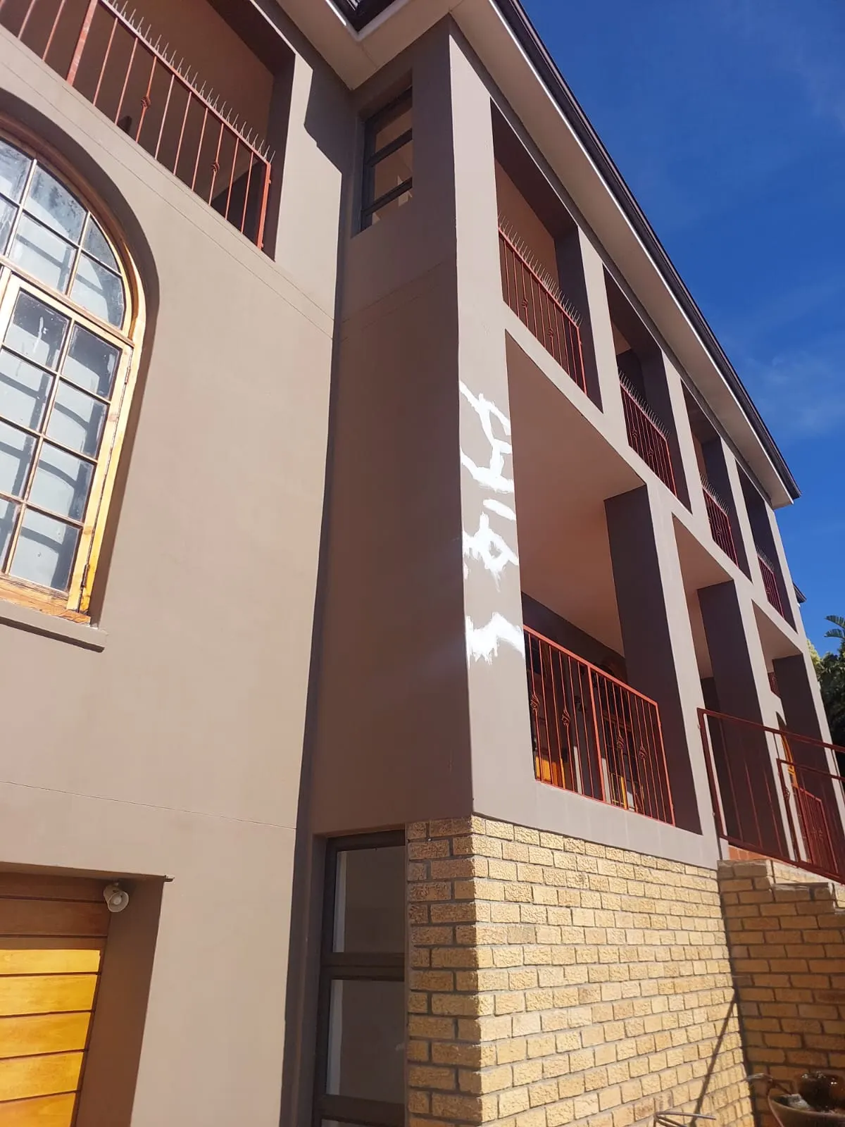 Painted exterior walls with face brick base and balconies