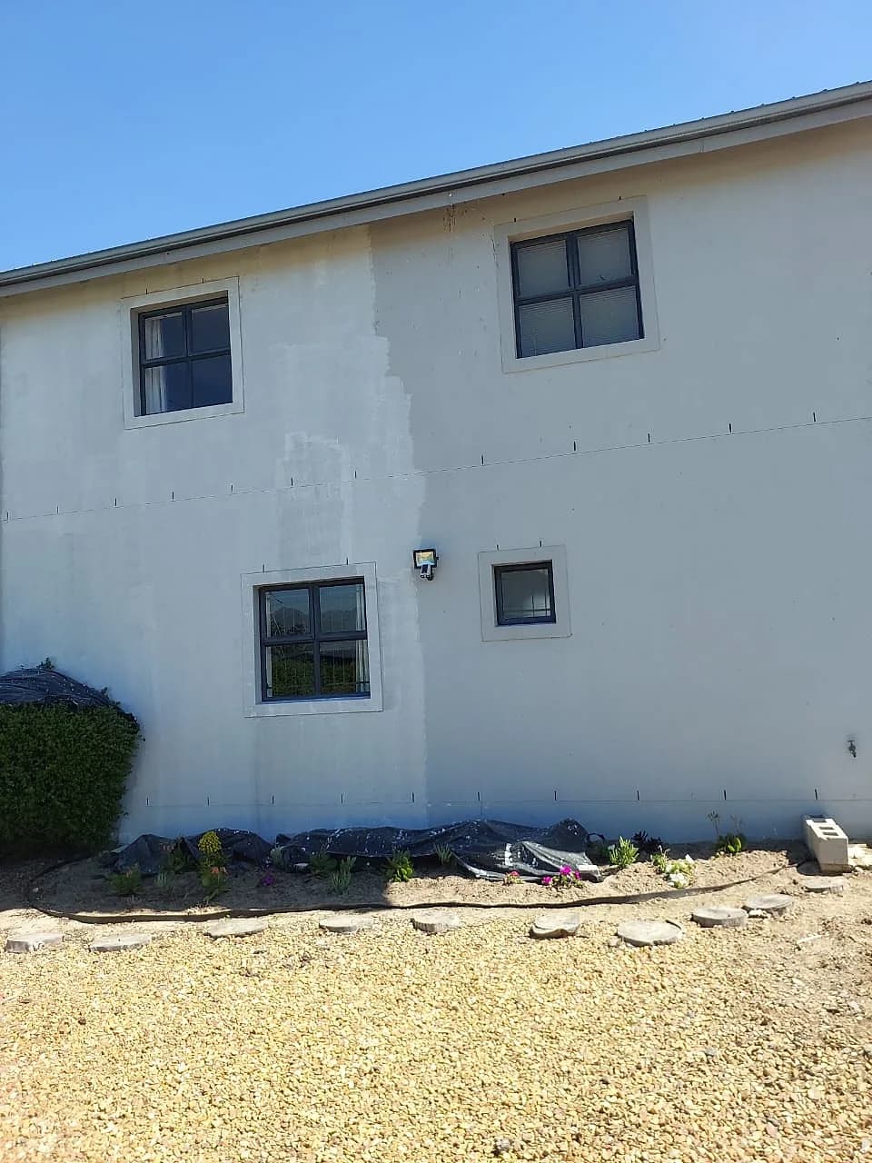 Exterior walls patched and primed before painting