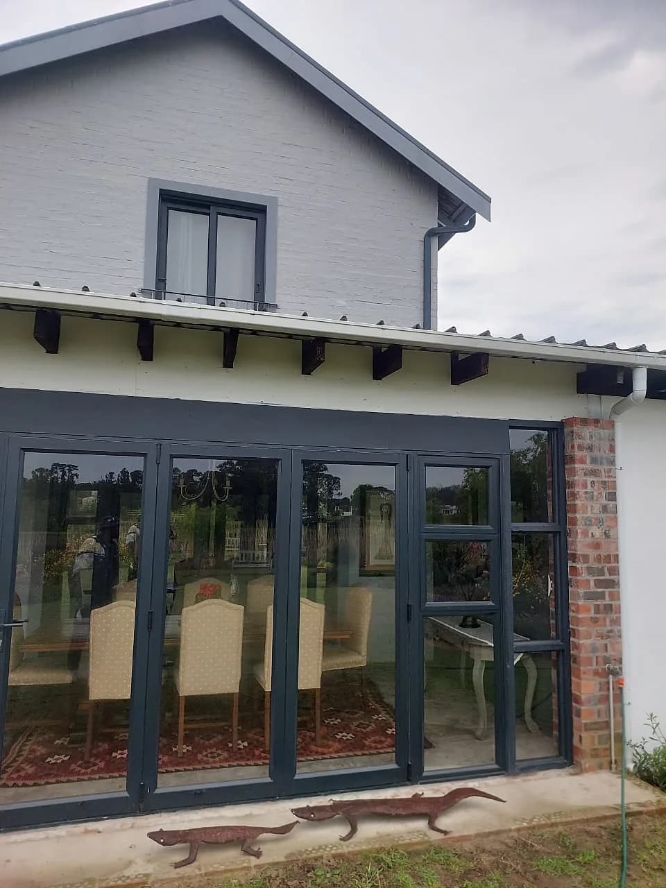 Painted house exterior with bifold doors opening onto a patio