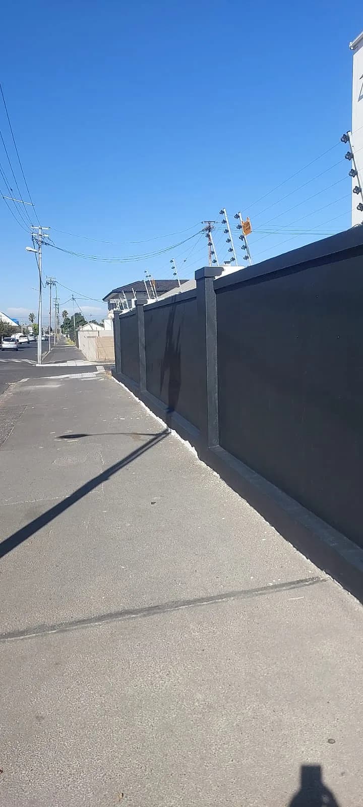 Long street-facing boundary wall freshly painted