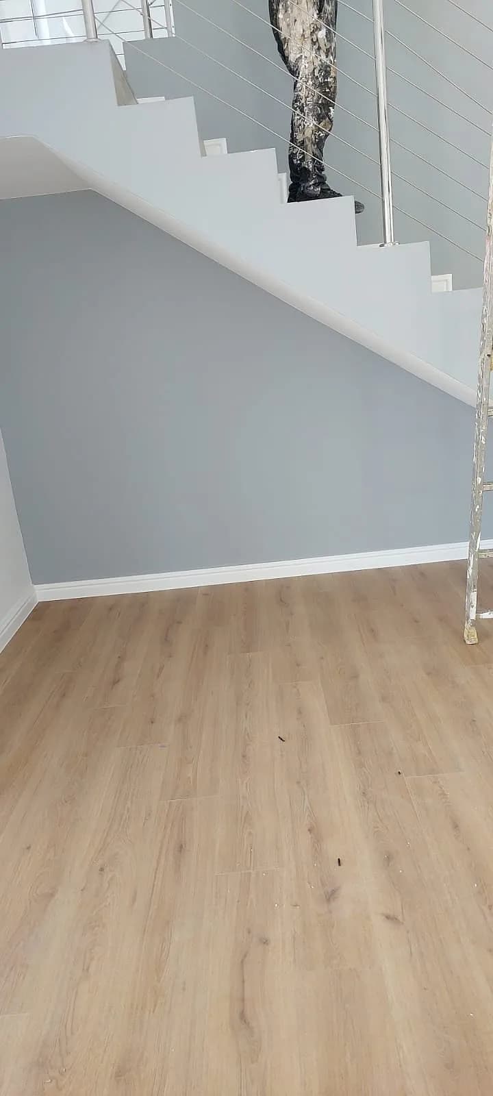 Interior painting under a staircase with new wooden flooring